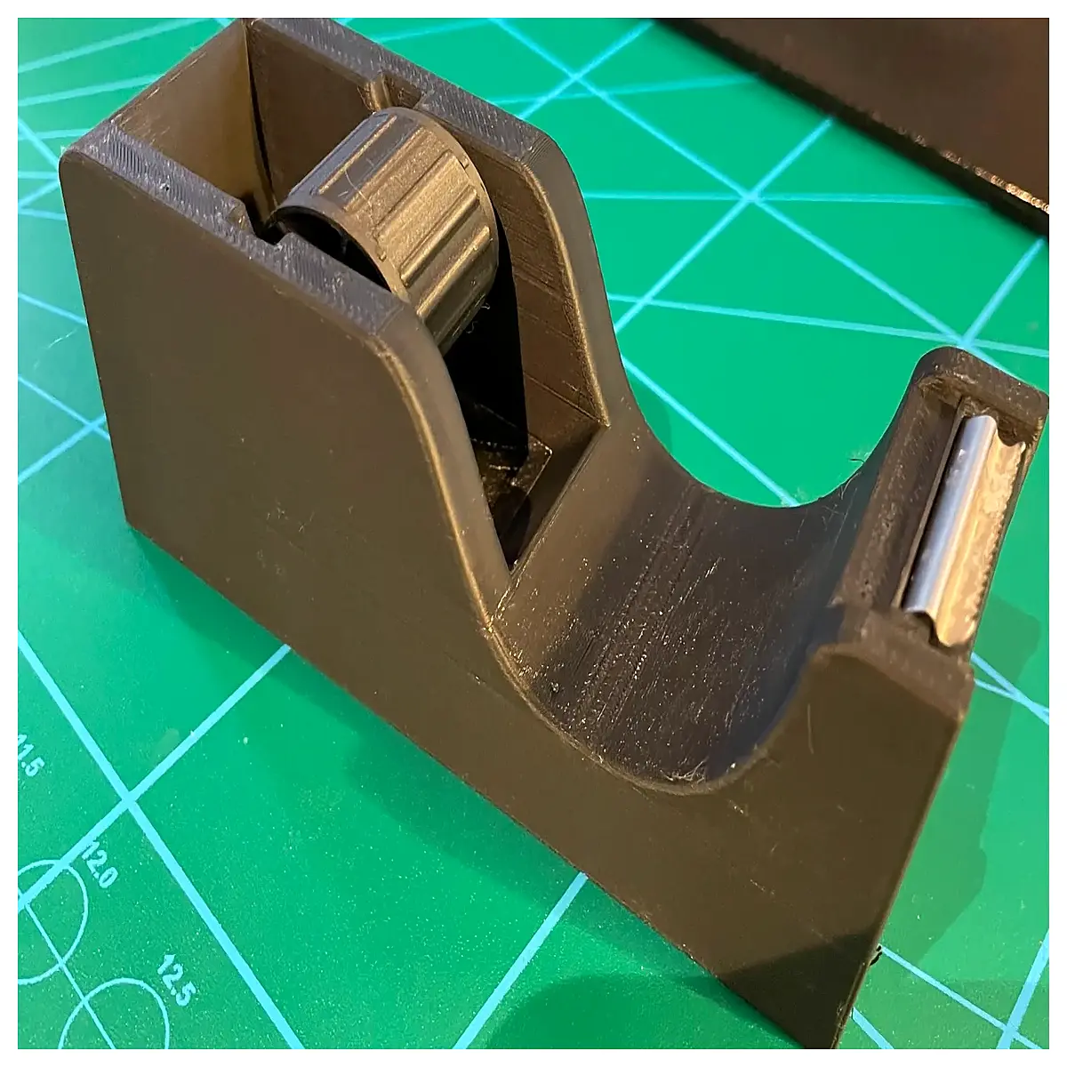 duty tape dispenser with hole for cutting boxes and packing supplies